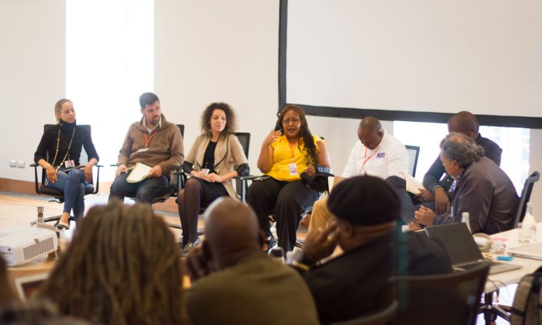 A photo of people in a row of seats taking part in a a panel discussion at the MenEngage Alliance Strategy Meeting in 2018